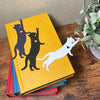 Fun cat bookmarks with a hanging paw and pink toe beans. Bookmarks shown in purple and black sparkle, as well as white