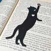 Fun cat bookmark with a hanging paw and pink toe beans. Bookmark shown in  black sparkle.
