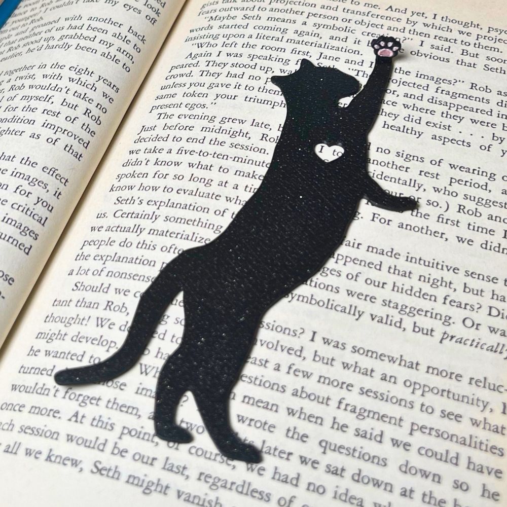 Fun cat bookmark with a hanging paw and pink toe beans. Bookmark shown in  black sparkle.