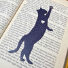 Fun cat bookmark with a hanging paw and pink toe beans. Bookmark shown in  purple sparkle.