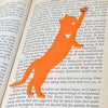 Fun cat bookmark with a hanging paw and black toe beans. Bookmark shown in orange.