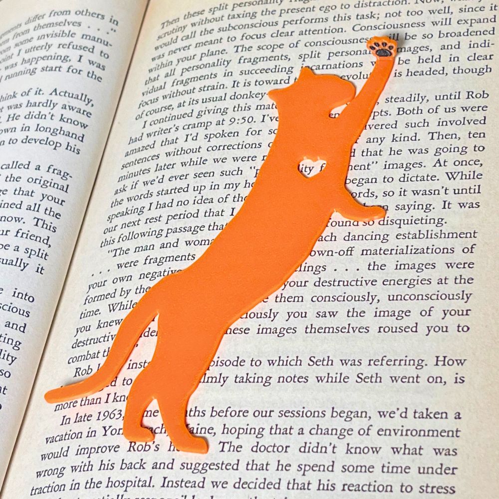 Fun cat bookmark with a hanging paw and black toe beans. Bookmark shown in orange.