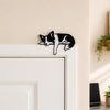 Border Collie shelf pet perched on a white door frame corner as a sleepy door topper