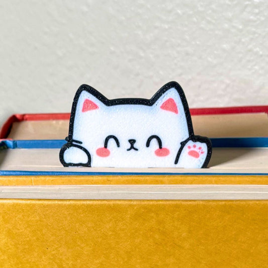 Adorably cute Kawaii cat bookmark peeking out of a yellow book