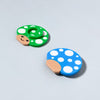 Happy little mushroom lip balm holders in cyan blue and green showing the top and bottom of the product