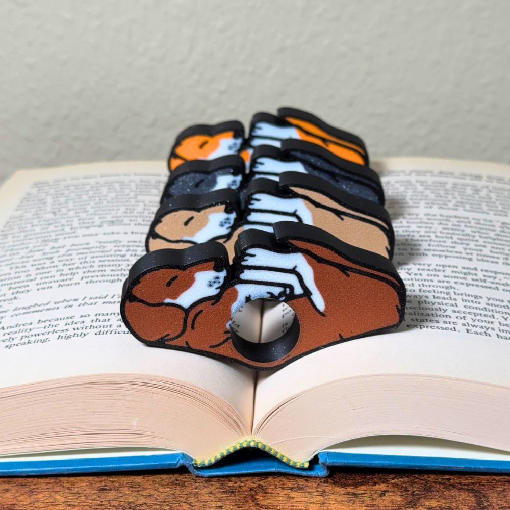 All 4 fur color variations for the dual color adorable sleeping puppy dog book page holders shown in a book from the front view