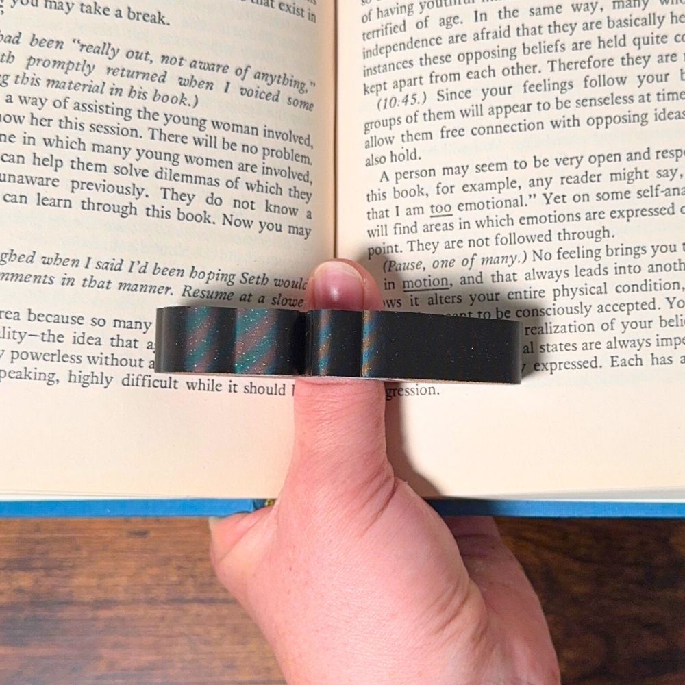 Adorable sleeping brown and white fur dog book page holder shown holding a book open from the top view