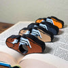 All 4 fur color variations for the dual color adorable sleeping puppy dog book page holders shown in a book from an angle