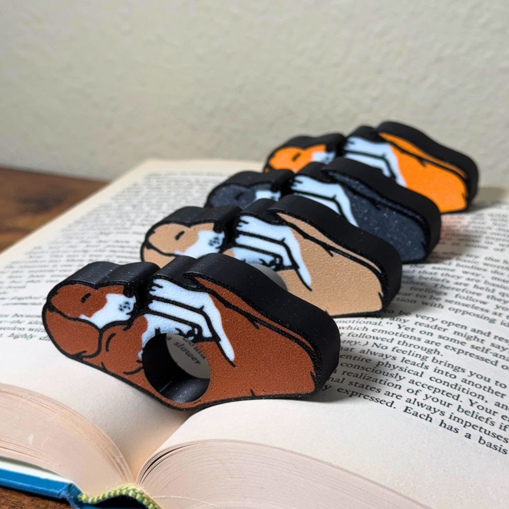 All 4 fur color variations for the dual color adorable sleeping puppy dog book page holders shown in a book from an angle