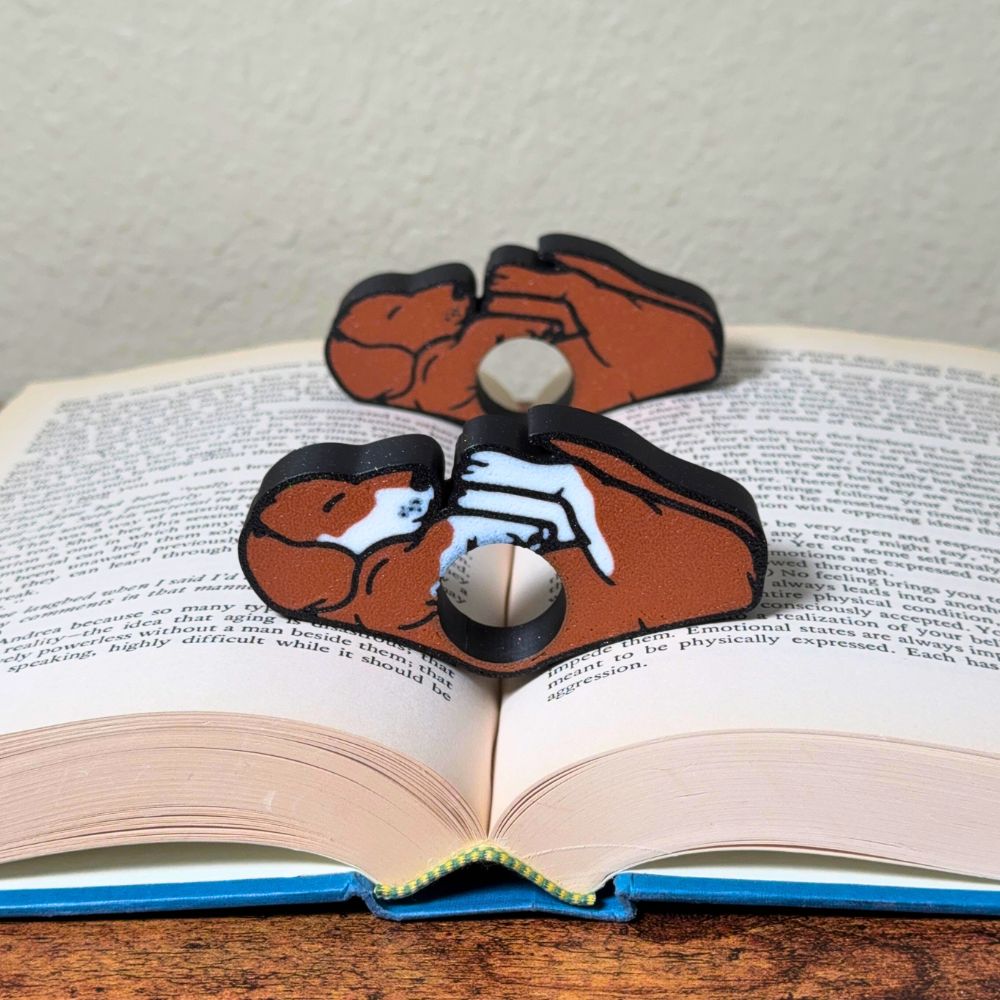 Adorable sleeping brown and white dog book page holders shown in a book