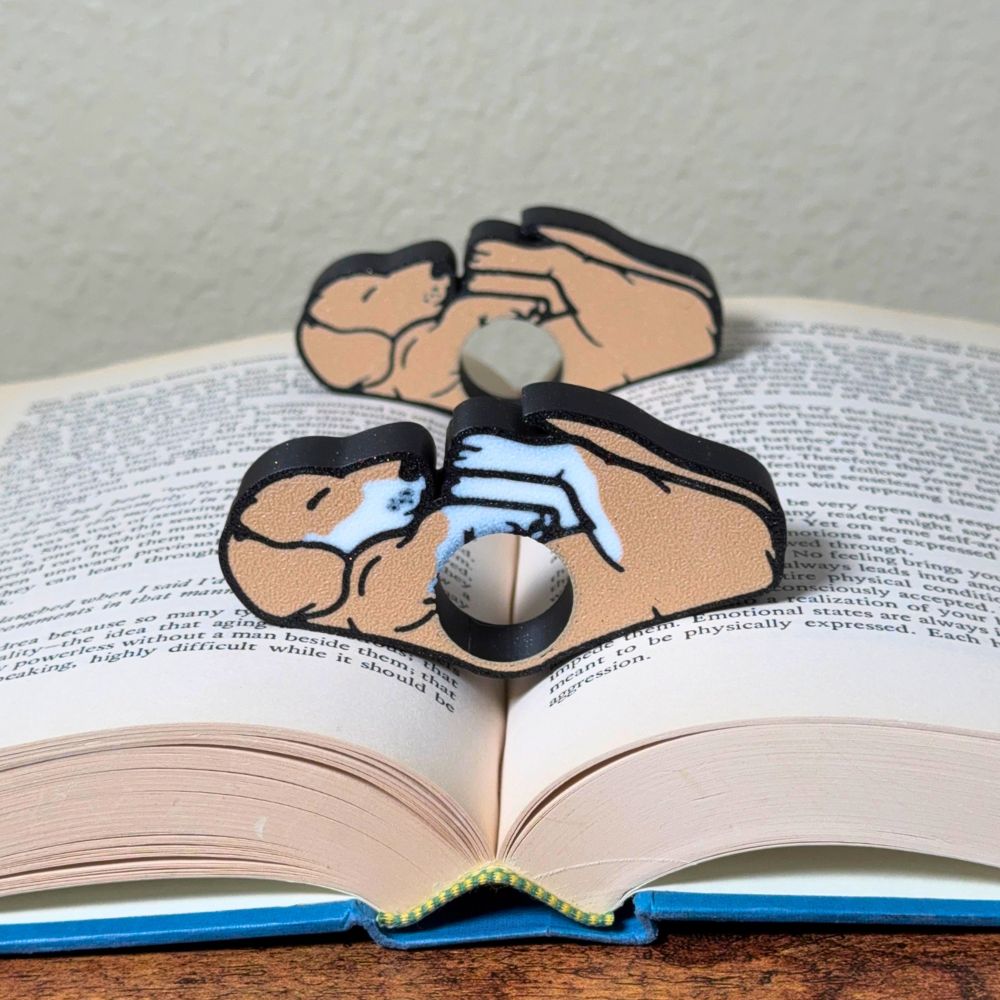 Adorable sleeping tan and white dog book page holders shown in a book