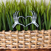 Skeleton bone hands in a heart shape inside of a houseplant