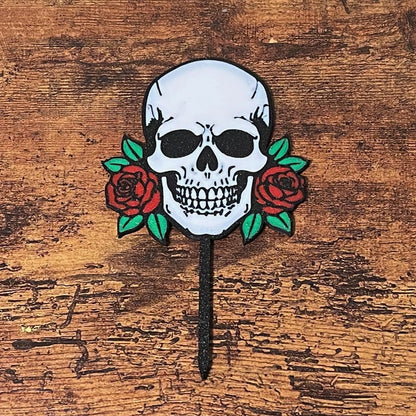 Gothic skull head with red roses shown on a wooden surface