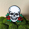 Gothic skull head with red roses on each side shown in a moss houseplant