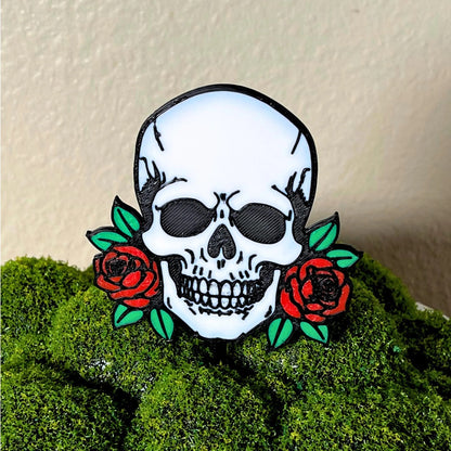 Gothic skull head with red roses on each side shown in a moss houseplant