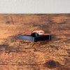 Front side of adorable sleeping sloth book page holder shown on wooden surface