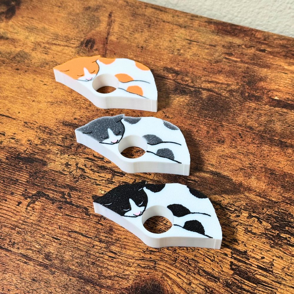 The front of the spotted cat page holders on a wooden table from the side view