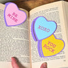 Sweet set of three bookmark hearts in pink, blue and yellow inside a open book
