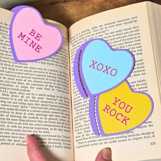 Sweet set of three bookmark hearts in pink, blue and yellow inside a open book